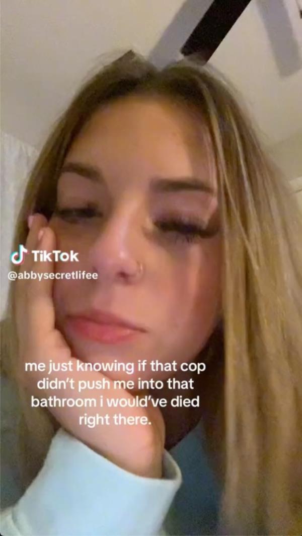 Screenshot of Abby Ayers' TikTok captioned “me just knowing if that cop didn’t push me into that bathroom i would’ve died right there.”